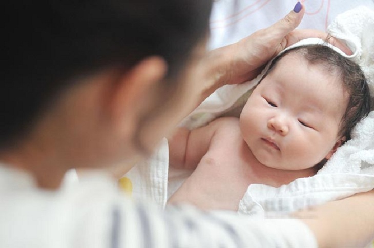 Lau người bằng khăn ấm để hạ sốt cho trẻ